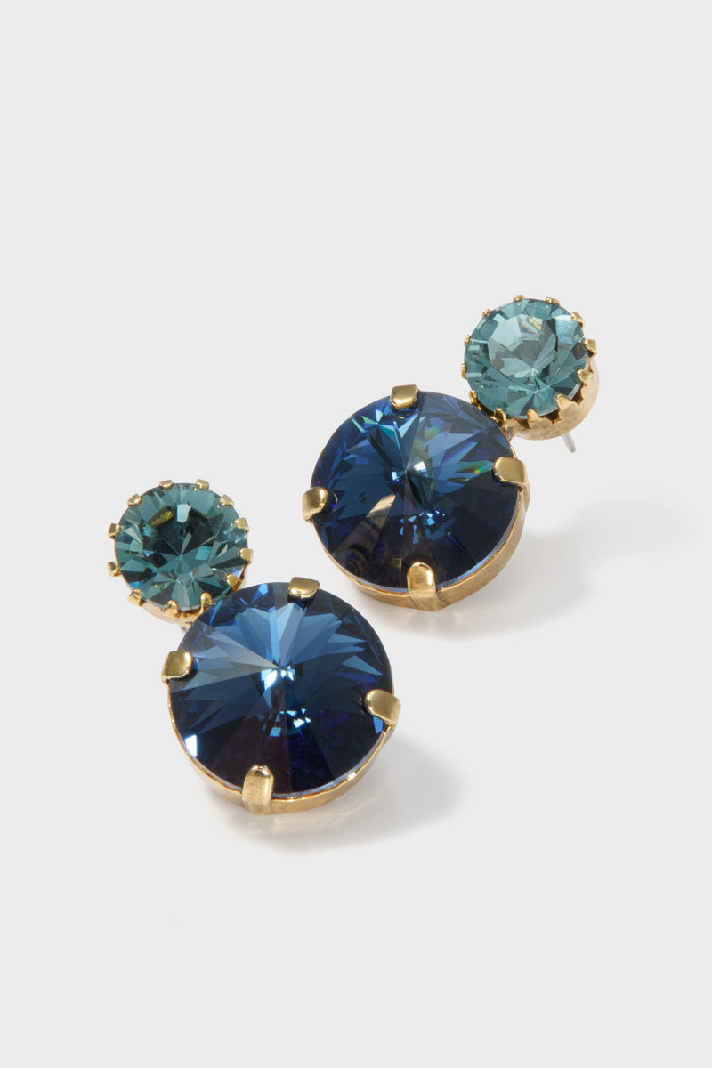 Lagoon Myrla Earrings: Classic stud earrings featuring navy and teal faceted crystals in gold-tone prongs for an effortless, high-end sparkle; perfect for fun, elegant occasions.