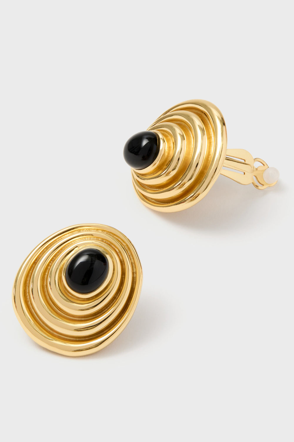 VALERE 22K gold-plated circular clip-on earrings with concentric ring design and central black onyx stones, shown on a light background—a stunning addition to any luxury jewelry collection.