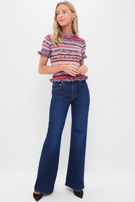 Woman models Madison Kimberly 70's Flare jeans, high-rise with a classic flared leg, embodying effortless style and comfort, paired with a ribbed knit top.