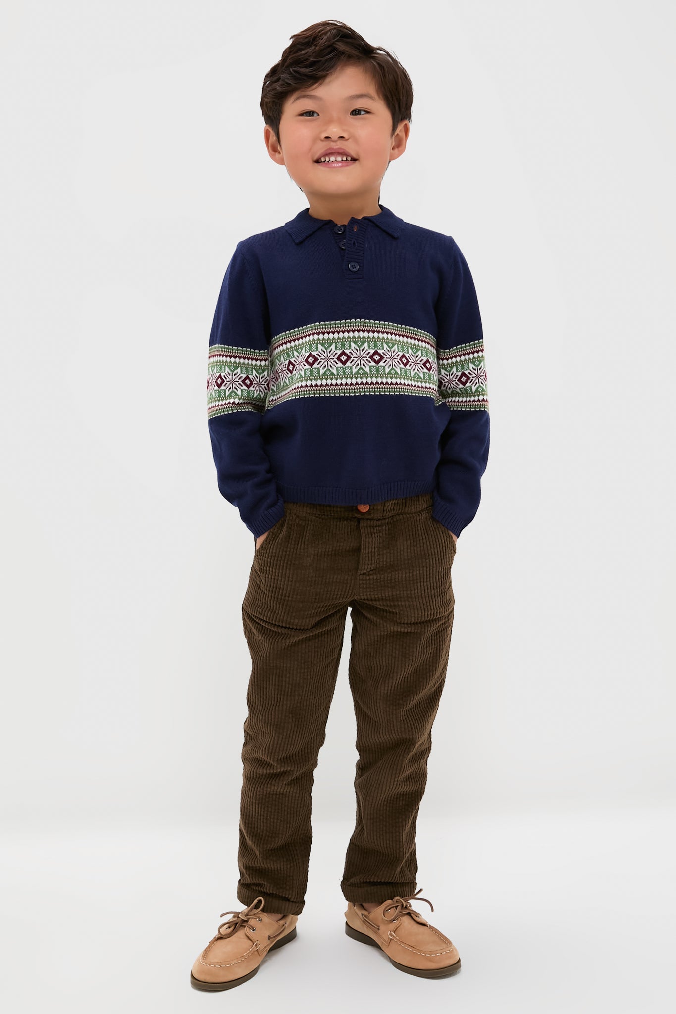 Boy in a classic Fairisle Collar Sweater, navy with geometric patterns, paired effortlessly with corduroy pants and boat shoes. Fun, high-end style for all occasions.