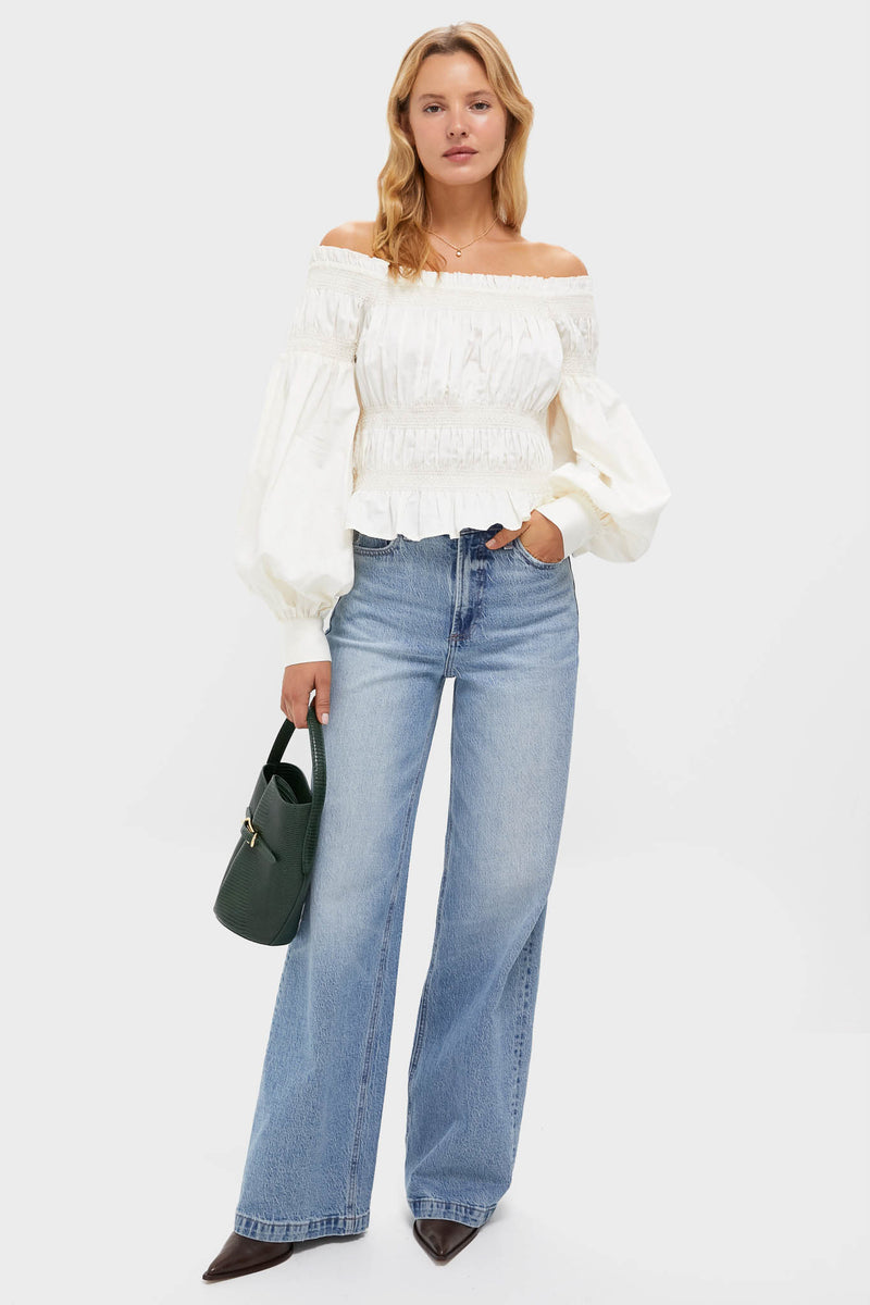 Model in an off-the-shoulder ivory blouse and wide-leg jeans, showcasing the classic Gold and Crystal Marie Necklace, an effortless, high-end piece perfect for any occasion.