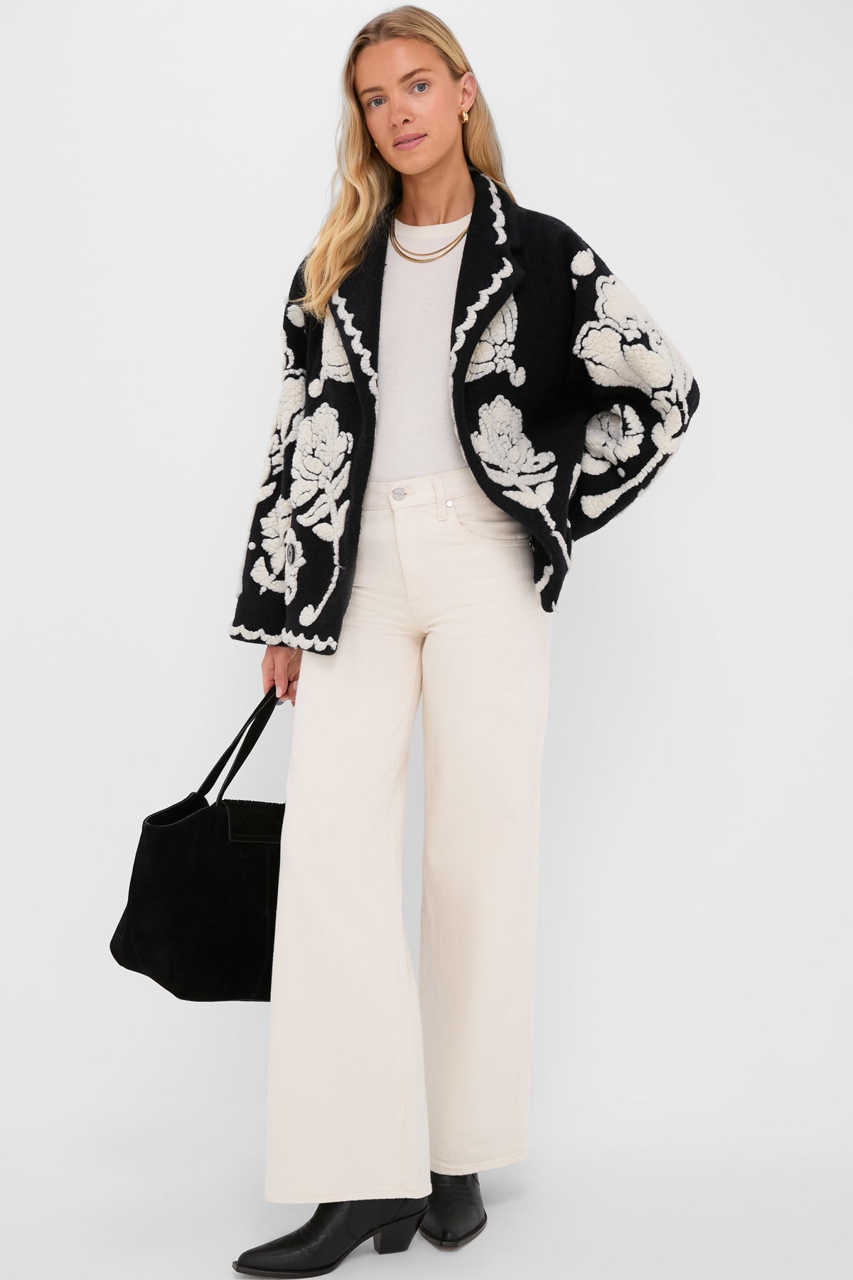 Model in a classic Black Cream Floral Arabesque Fleece Coat, showcasing an effortless, high-end style with wide-leg trousers and a chic tote.