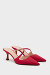 A pair of Tuckernuck Shoes red, pointed-toe slip-on mules with crisscross straps and mid-height heels, showcased on a plain white background.