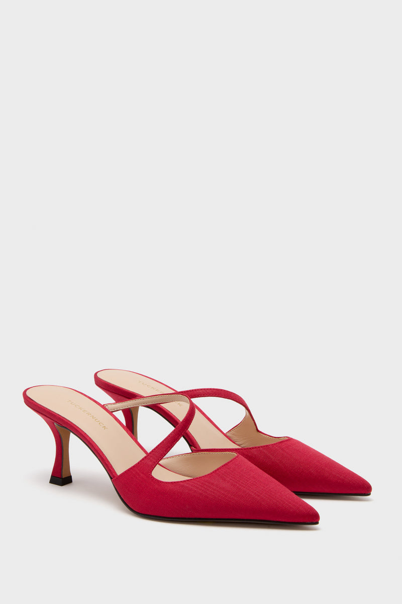 A pair of Tuckernuck Shoes red, pointed-toe slip-on mules with crisscross straps and mid-height heels, showcased on a plain white background.