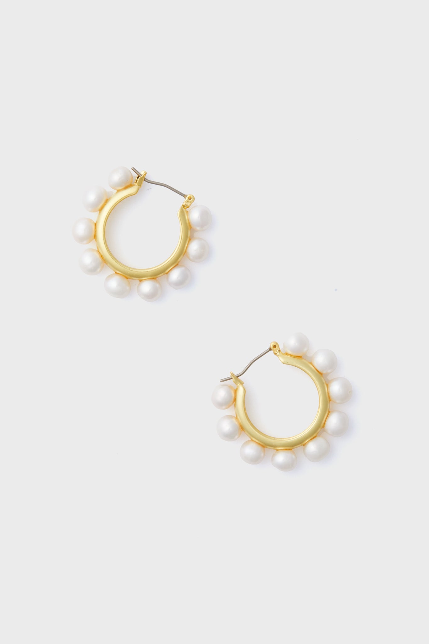 Tuckernuck Jewelry gold hoop earrings, each accented with evenly spaced white pearls, offer a refined and elegant accessory.
