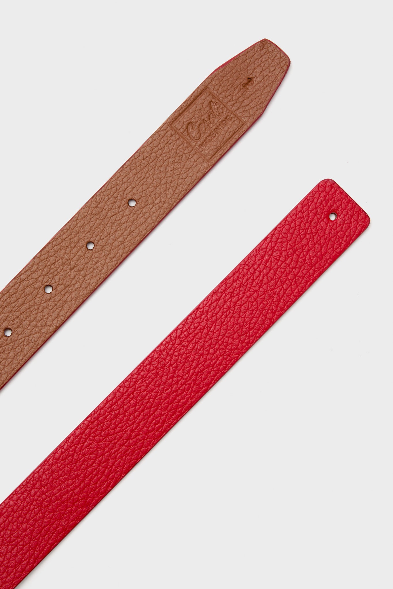 Maraschino and Biscotti Belt: Classic, reversible leather belt with pebbled tan and red textures, designed for effortless, high-end styling. Buckle sold separately.