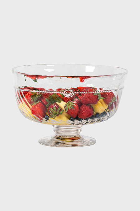 A hand-crafted Juliska glass trifle bowl overflows with mixed fruit—strawberries, pineapple, and blueberries—for a show-stopping centerpiece on any table.