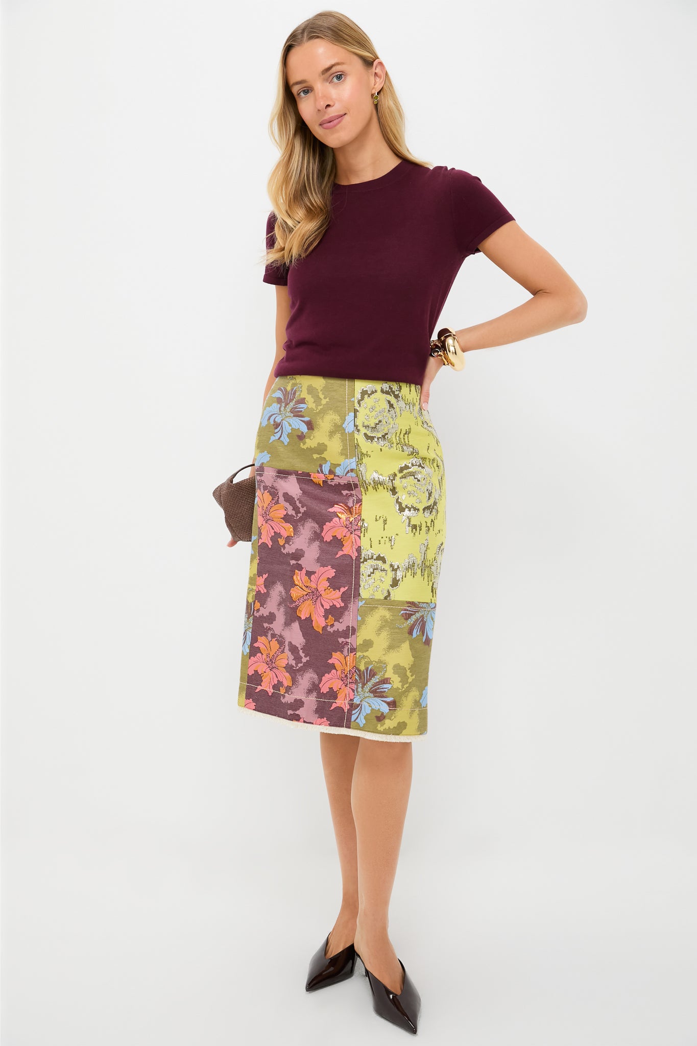 Model showcasing Olive Crystal Remy Earrings with shimmering olive glass stones, paired with a stylish burgundy top and floral patchwork skirt, capturing effortless, high-end style.