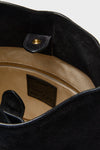 Black Suede Belted Bucket Bag interior with beige canvas lining, gold-tone zipper pocket, magnetic snap, and “Liner” label, highlighting classic, effortless, and high-end design.