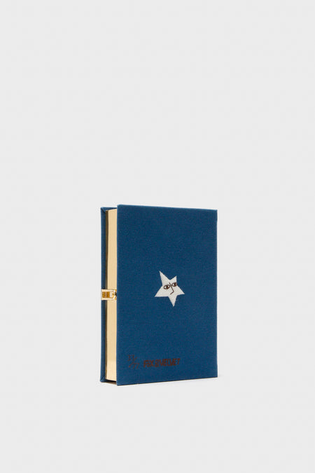 Indigo Latim Manhattan Cocktail Book Clutch in deep blue with star motif and gold interior, exudes classic, effortless elegance and fun for high-end occasions.
