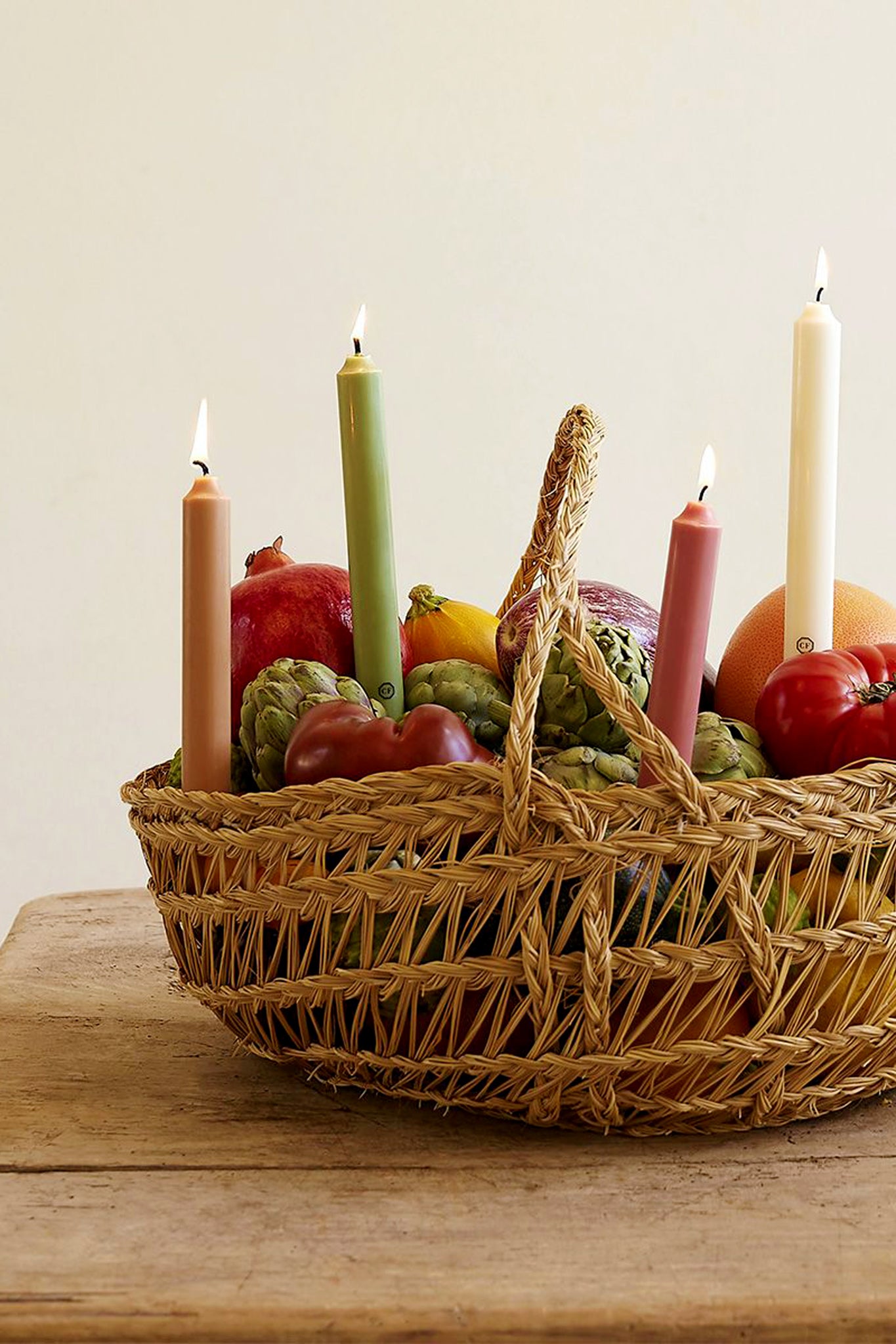 Effortlessly elevate your table with Spearmint Scented Taper Candles nestled among fruits, offering a classic, high-end touch to any setting.
