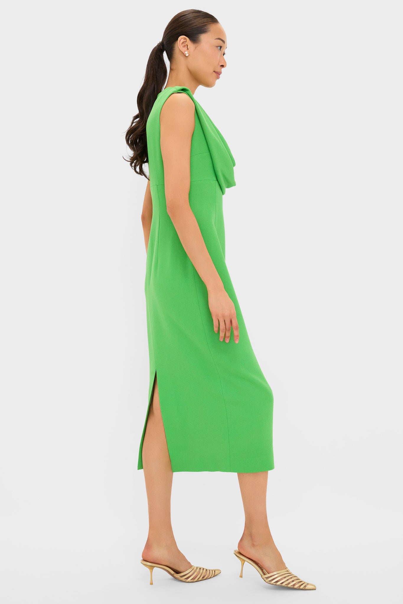 Model in profile wearing the Fresh Green Yuri Gown, a classic, high-end dress featuring an effortless draped cowl neckline and fun side slit.