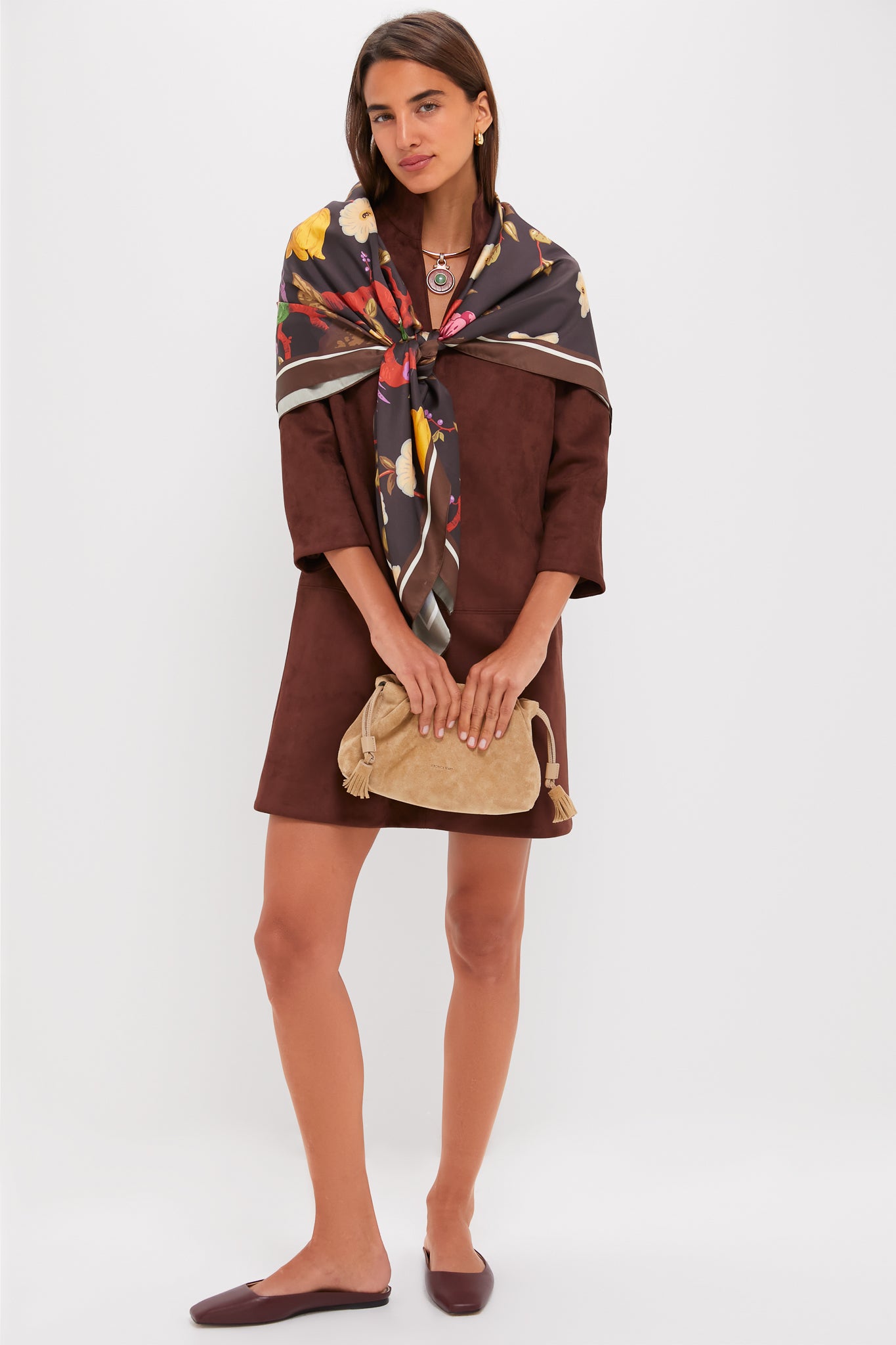 Woman models the classic Ganache Vegan Suede Clifton Dress, featuring three-quarter sleeves and V-neckline, paired with elegant accessories for an effortless, high-end look.