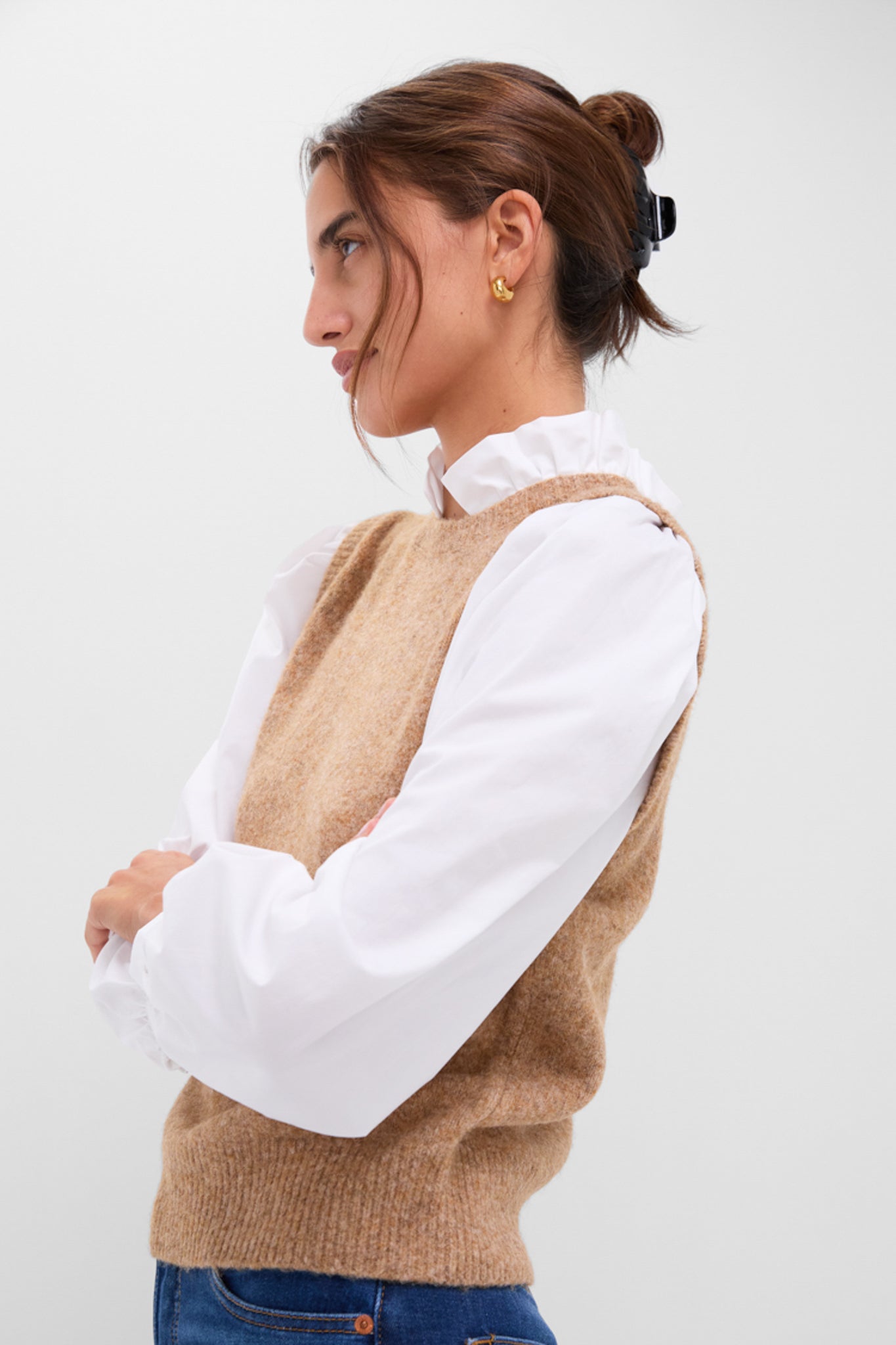 Young woman in a classic Desert Melange Ella Sweater Blouse, showcasing effortless style with a chic ruffle collar and sleeveless knit vest, exuding fun and high-end fashion.