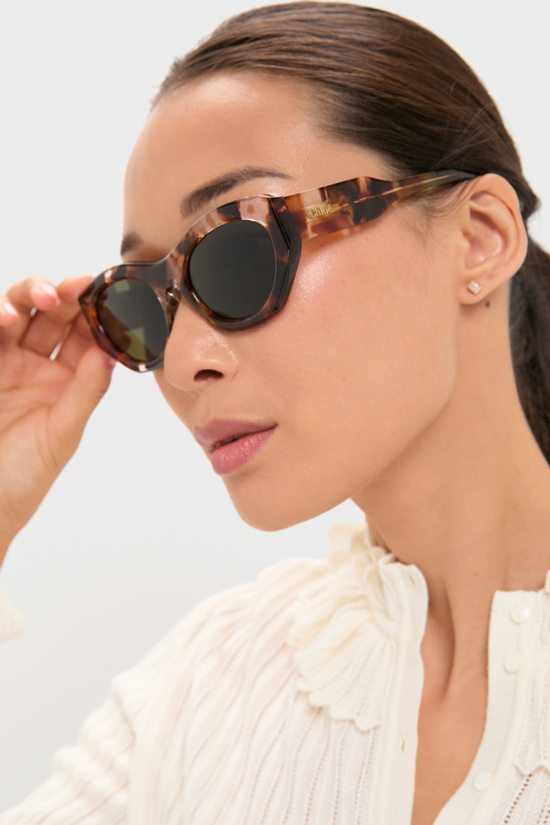 Young woman wearing Rust Havana Gayia Sunglasses, an effortless, high-end cat eye style with gradient lenses and tortoiseshell frame, epitomizing classic, fun elegance.