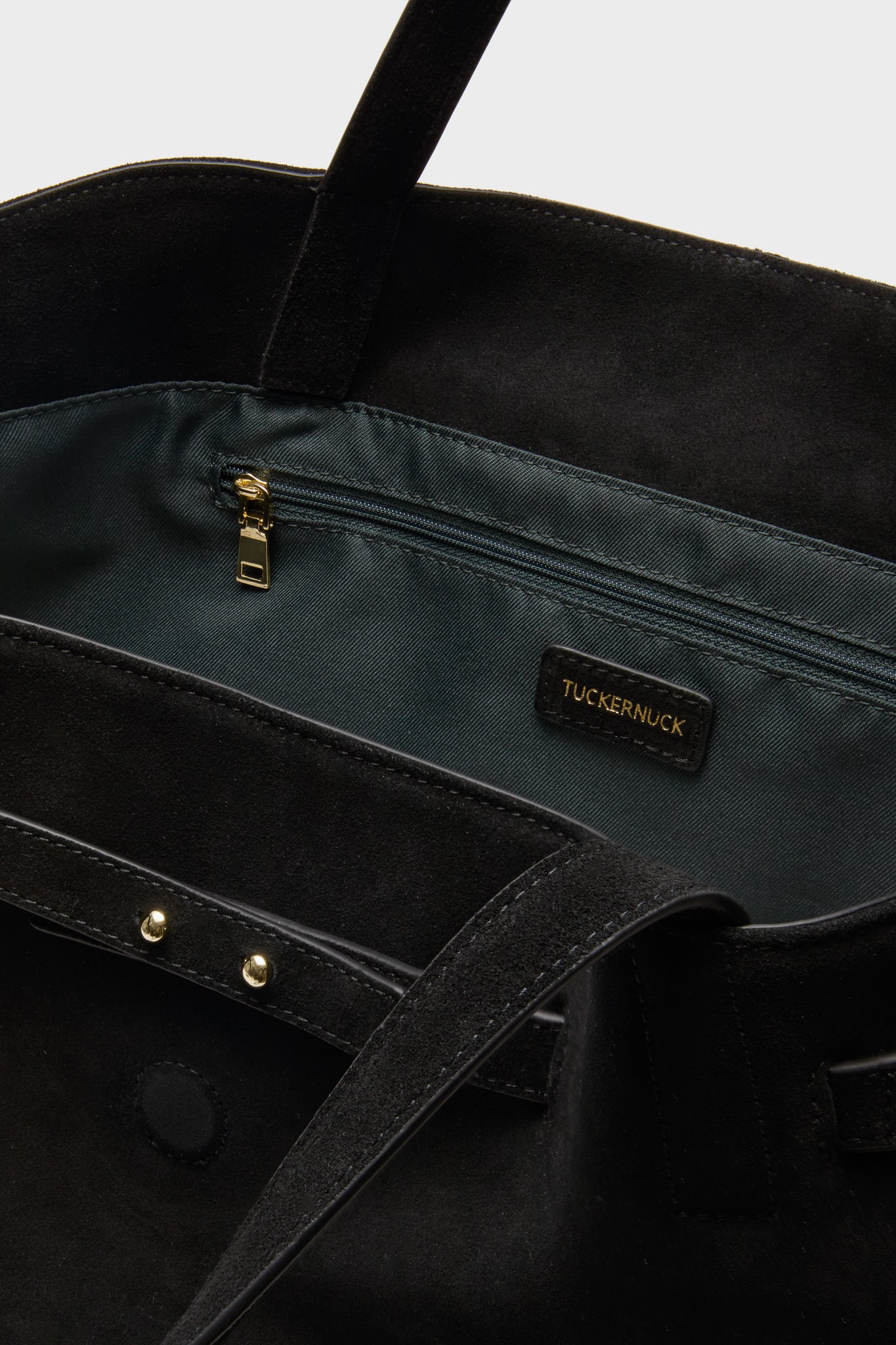 Black Suede Blaine Tote interior with dark lining, gold zip pocket, and TUCKERNUCK label; classic, high-end design for effortless, fun style.