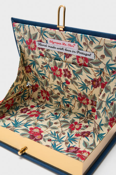 Inside the Indigo Latim Manhattan Cocktail Book Clutch, showcasing a classic, high-end floral lining with a handmade label, reflecting effortless style and fun sophistication.