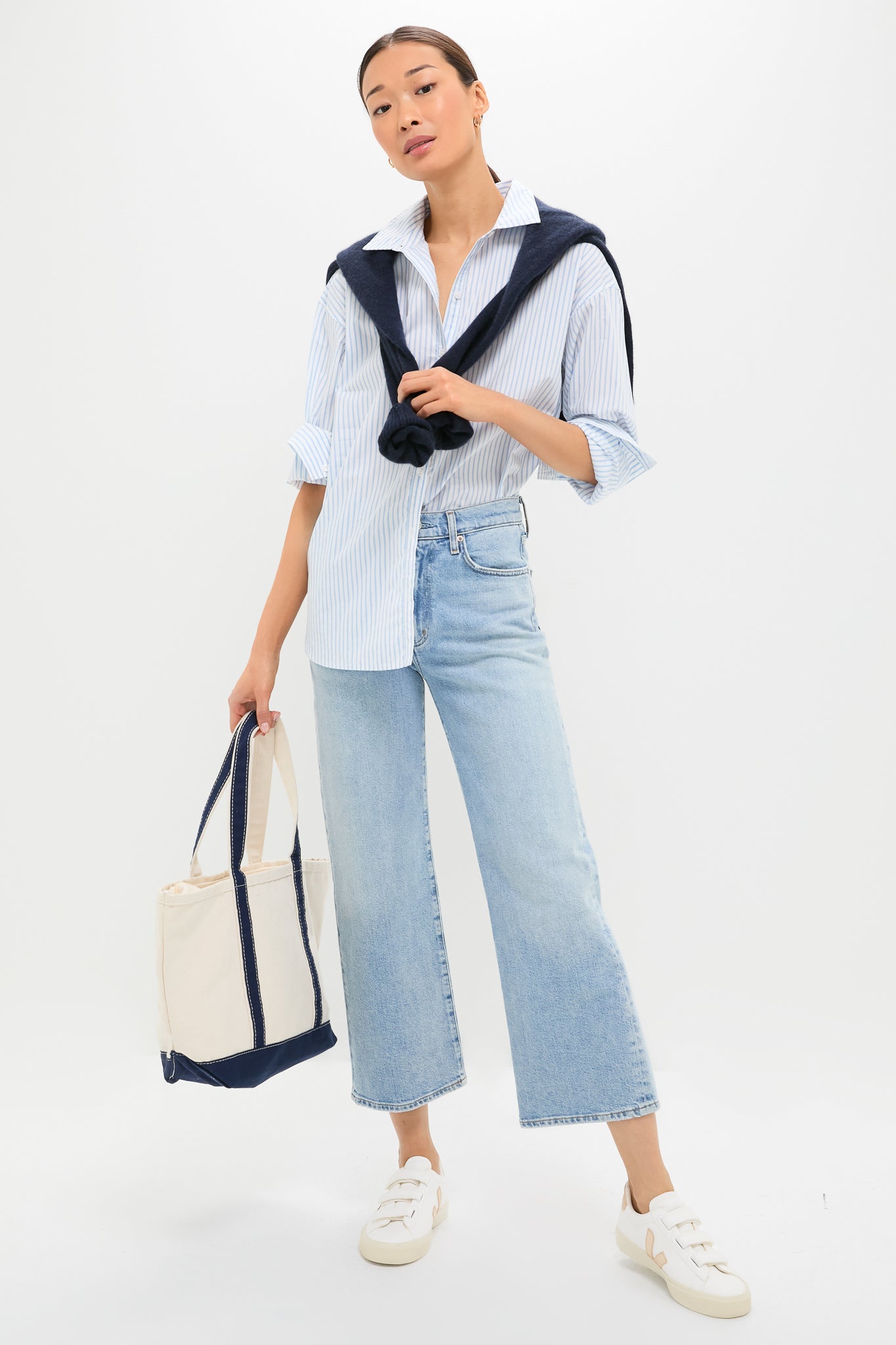 Young woman wearing Extra White Platine Recife Logo Sneakers, featuring metallic logo, velcro straps; styled effortlessly with casual outfit, epitomizing classic, fun, high-end fashion.