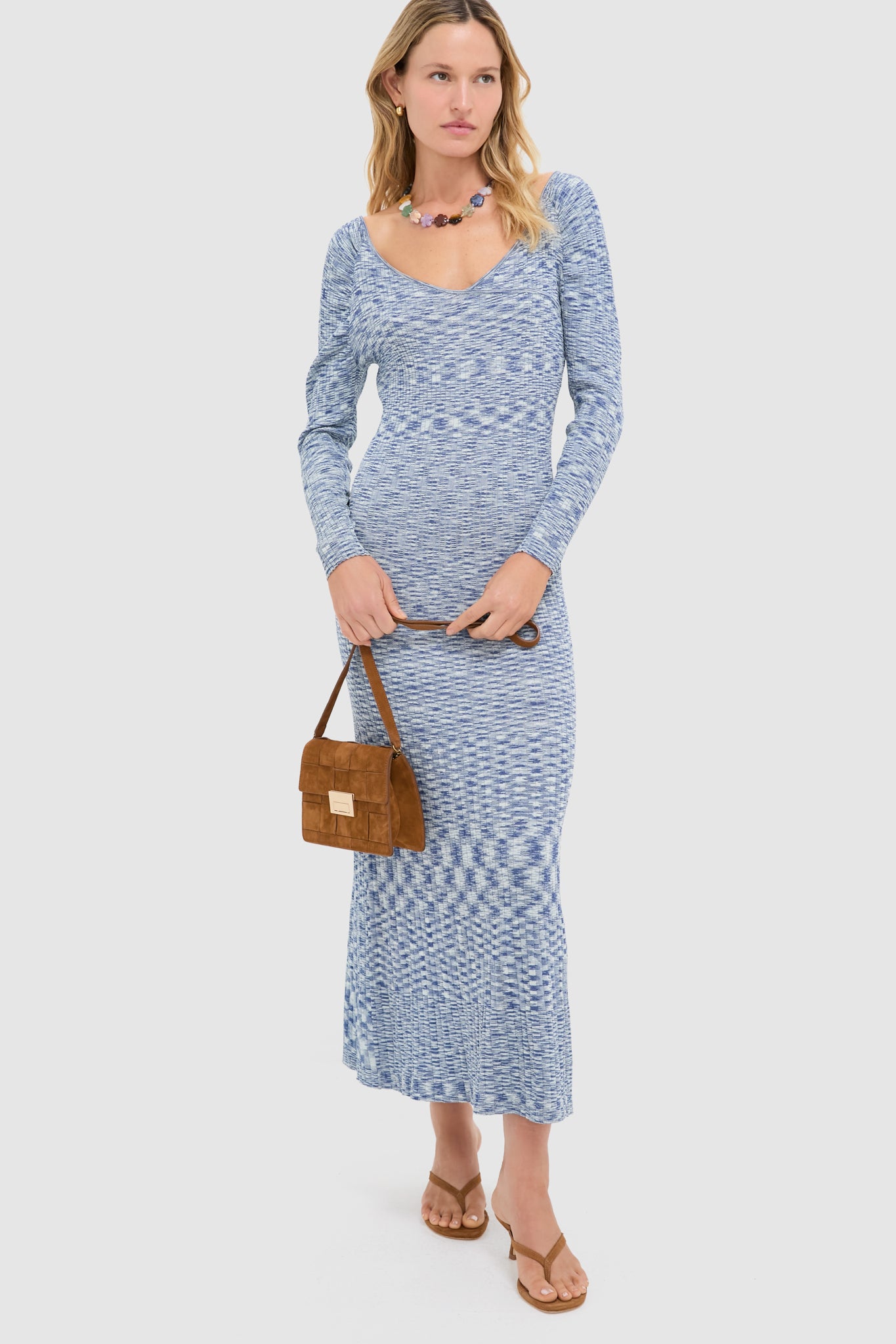 Model showcases the classic, high-end Woven Cacao Suede Delphine Crossbody Bag, exuding effortless style with its practical design and elegant suede finish.