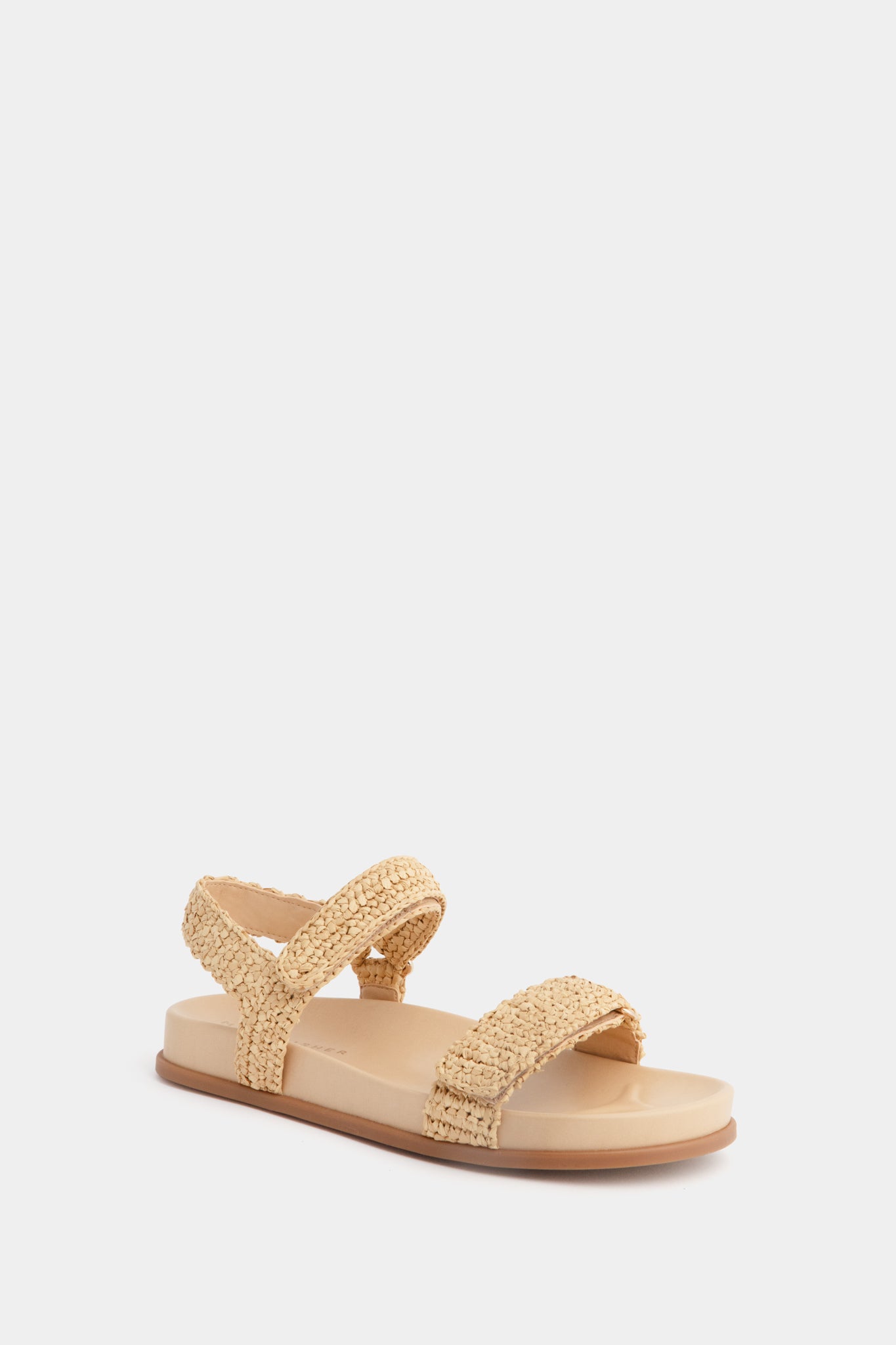 The Marc Fisher Lenore Sandal in beige showcases a woven upper with fabric straps over the toe and ankle, finished with a stylish slingback design.