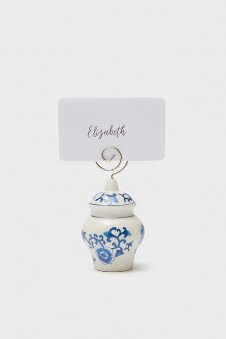 This elegant Ginger Jar Placecard Holder by Two's Company features a small white and blue ceramic jar with a blue floral pattern, metal holder, and a card labeled Elizabeth.