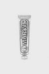 A Marvis toothpaste tube stands upright, offering fresh breath and a whiter smile.