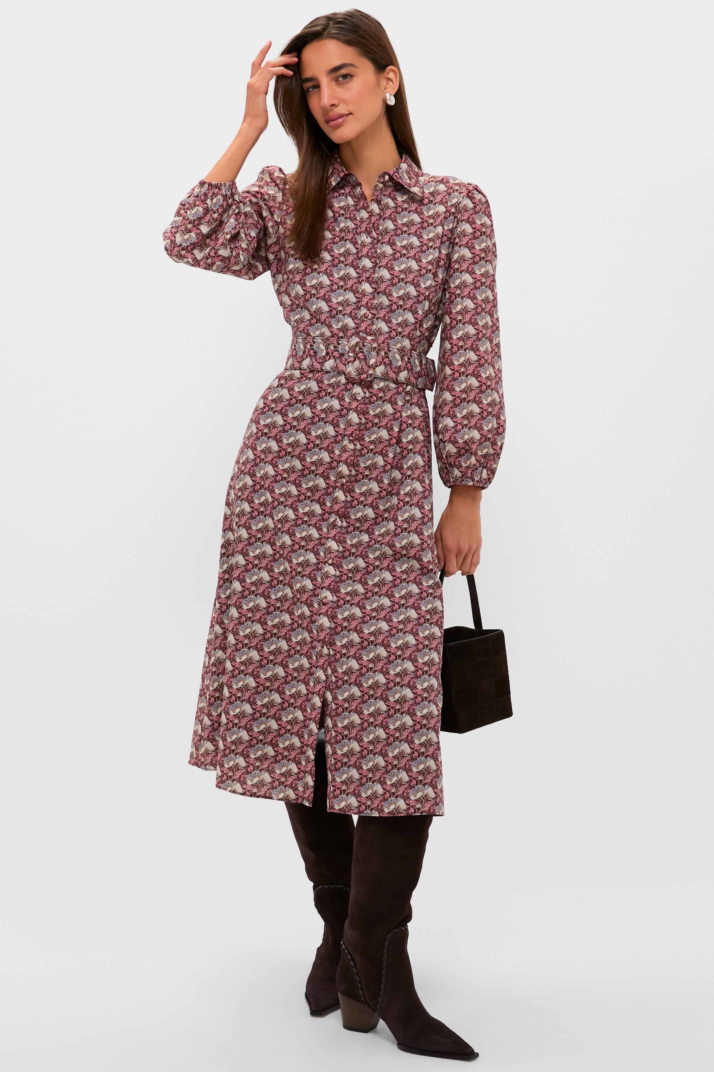 Woman in classic, effortless Plum & Dusty Blue Leafy Floral Kai Maxi Dress with elastic waist and front slit, accessorized with high-end knee-high boots and handbag.