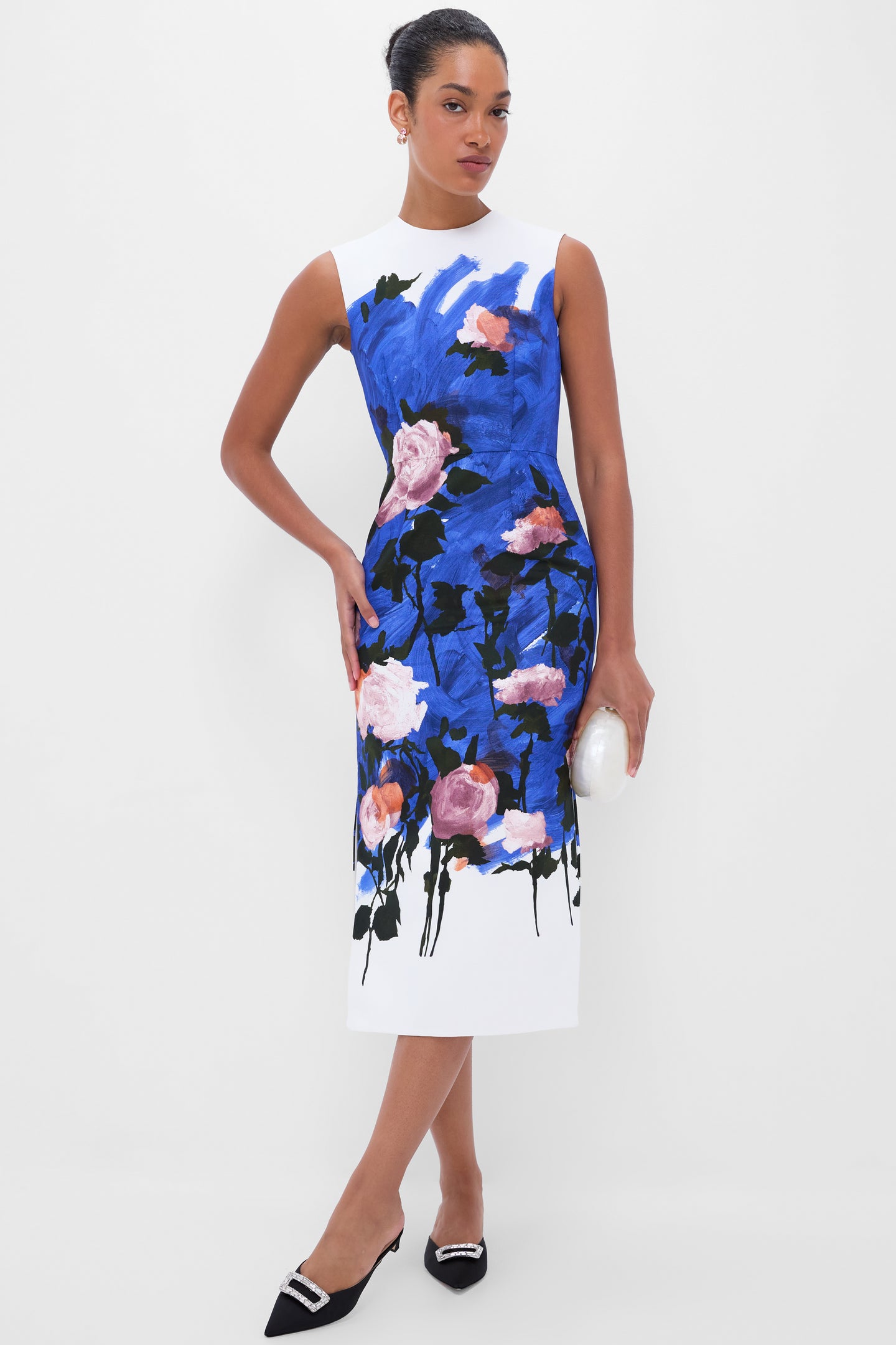 Woman in a classic sheath dress, holding an oval clutch, showcasing effortless style with high-end Rose Quartz Myrla Earrings, featuring prong-set crystals and 18K gold-plated brass.