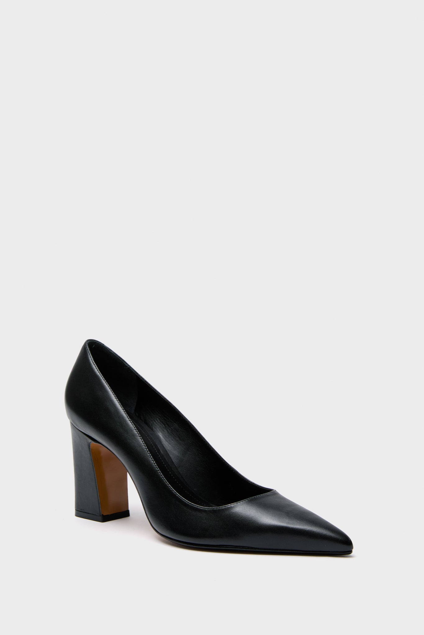 Schutz black leather pumps with a pointed toe and thick block heel, stylishly showcased.