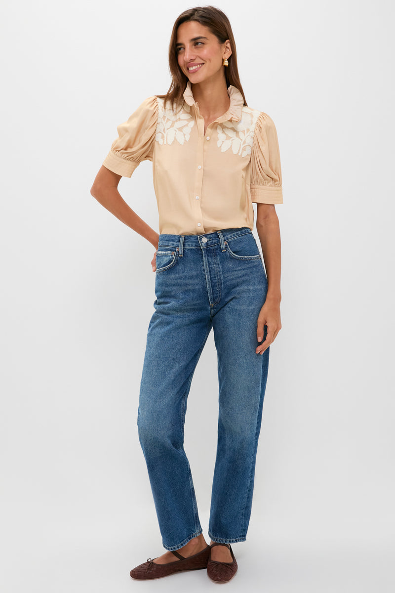 Model wears the Tan & Cream Embroidery Louisa Blouse with delicate leaf embroidery and ruffled collar, paired effortlessly with classic high-waisted jeans and dark woven flats.