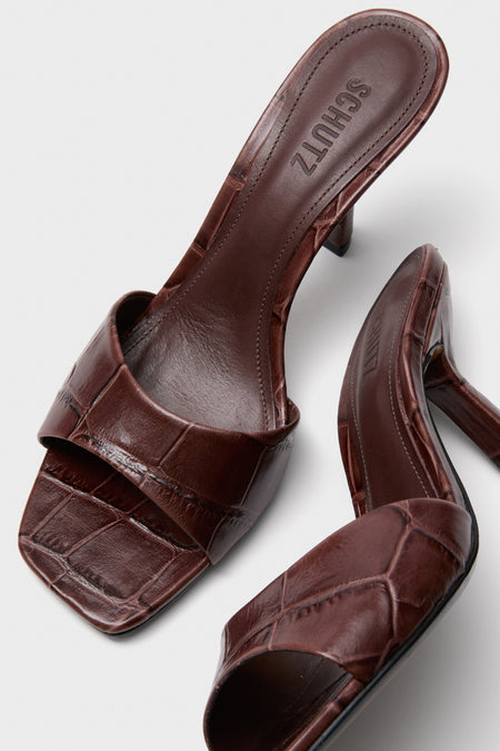 Root Brown Posseni Heels: Classic, effortless heeled mules in dark brown, crocodile-embossed leather with a square toe and angled heel, exuding fun and high-end style.