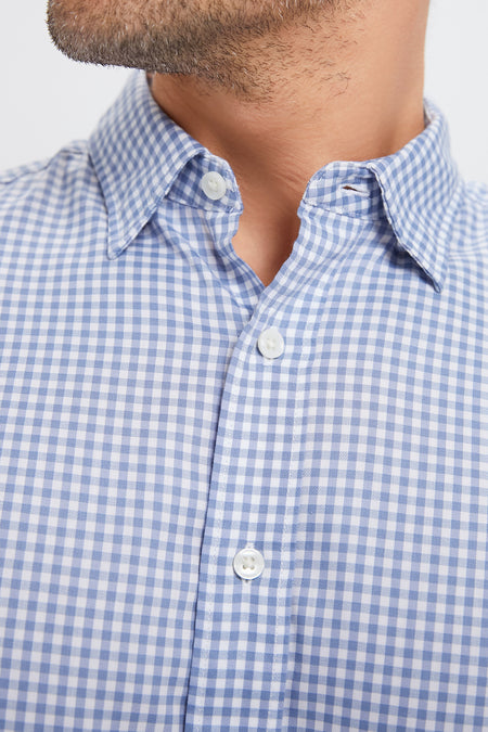 Man wearing the Light Blue Gingham Movement Shirt, showcasing its classic and effortless design with a button-down collar and high-end, wrinkle-free stretch fabric.