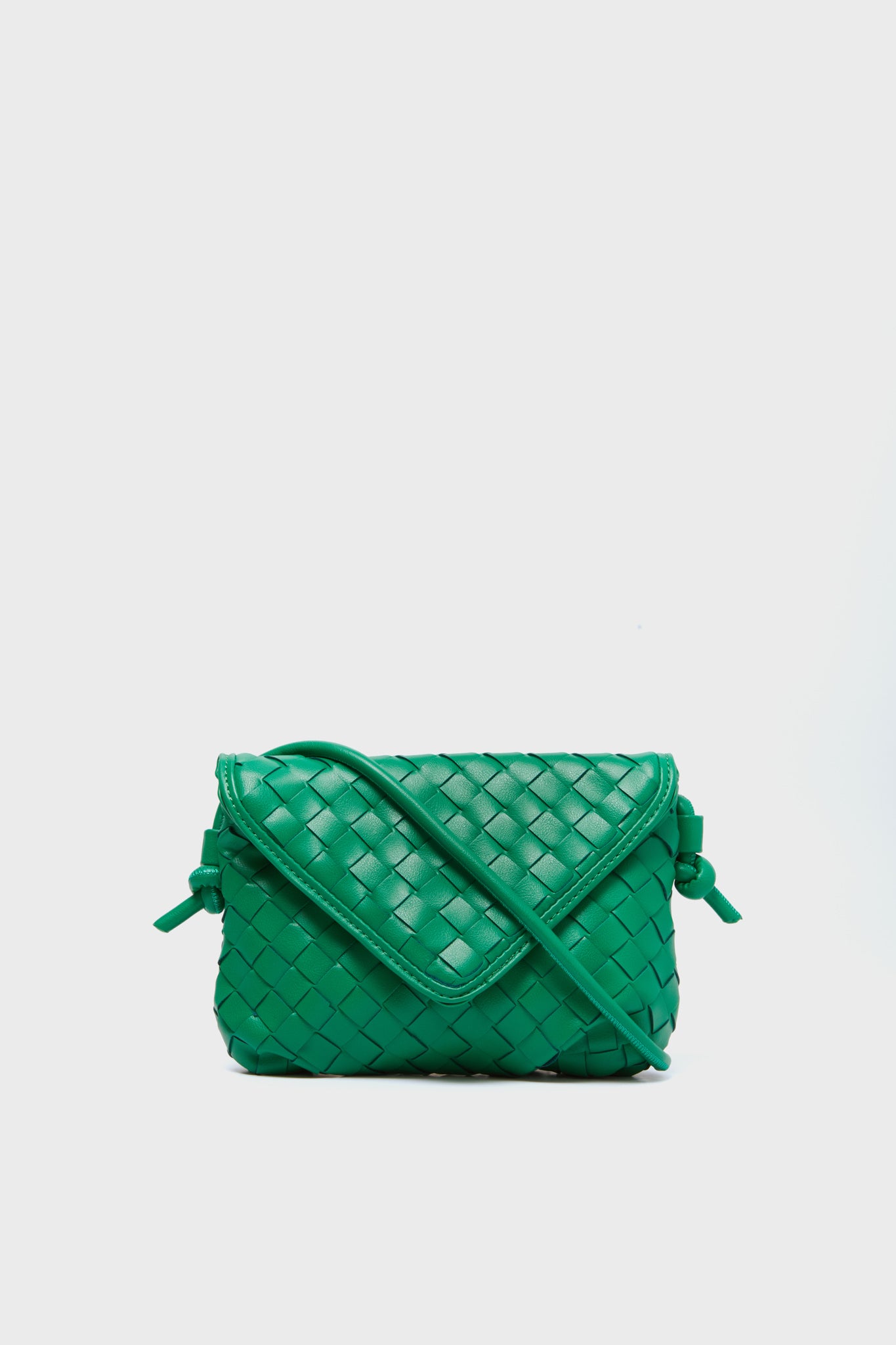 The Urban Expressions small green woven vegan leather crossbody bag features a flap closure and long strap, making it a stylish, animal-friendly accessory.