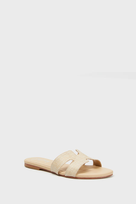 A beige slide sandal from French Sole featuring a woven textured upper and open toe, perfect for effortless summer style.