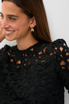 Smiling woman in the classic, high-end Black Lace Elodie Blouse with puff shoulders, showcasing an effortless and fun style for any occasion.
