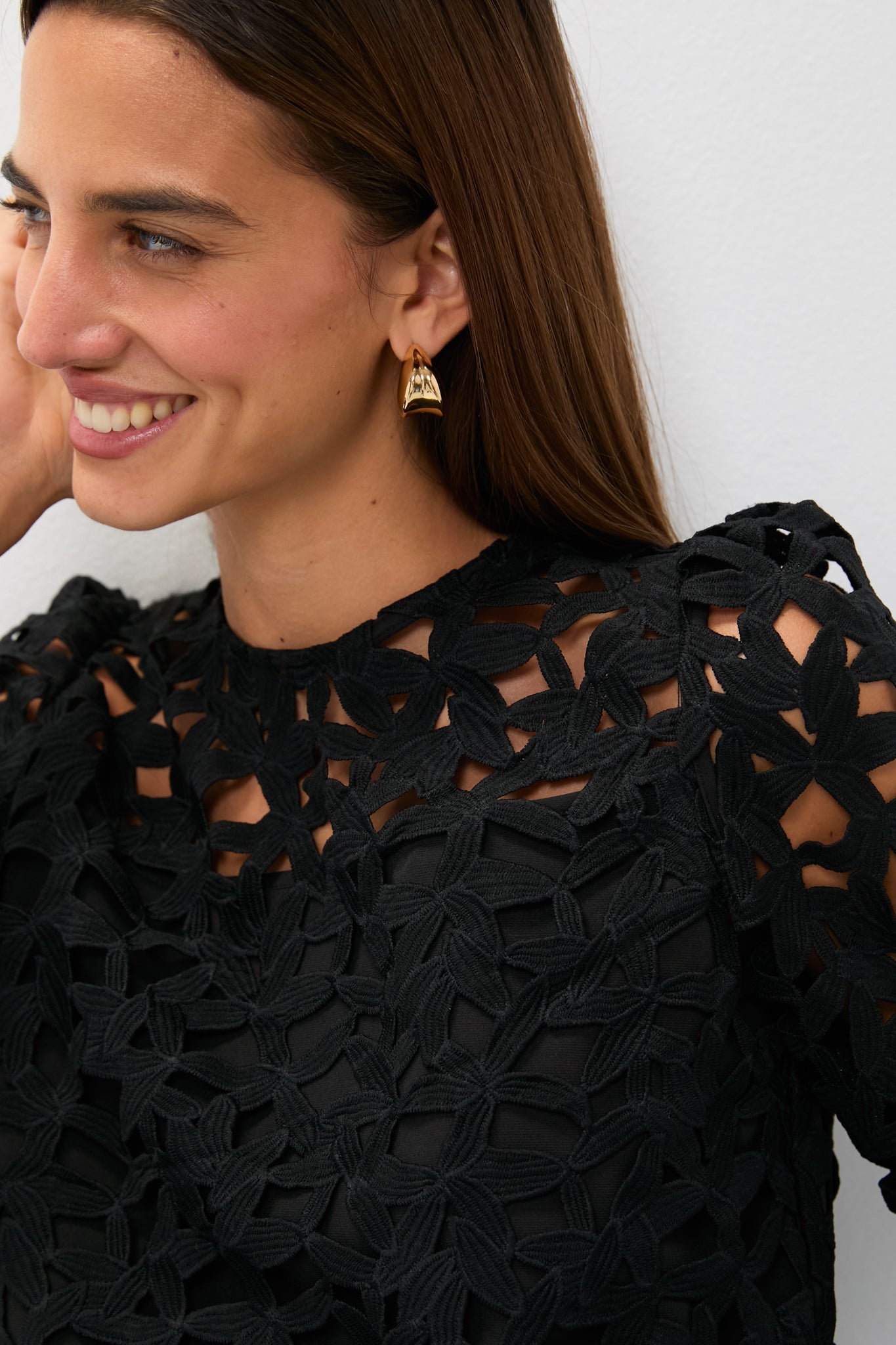 Smiling woman in the classic, high-end Black Lace Elodie Blouse with puff shoulders, showcasing an effortless and fun style for any occasion.