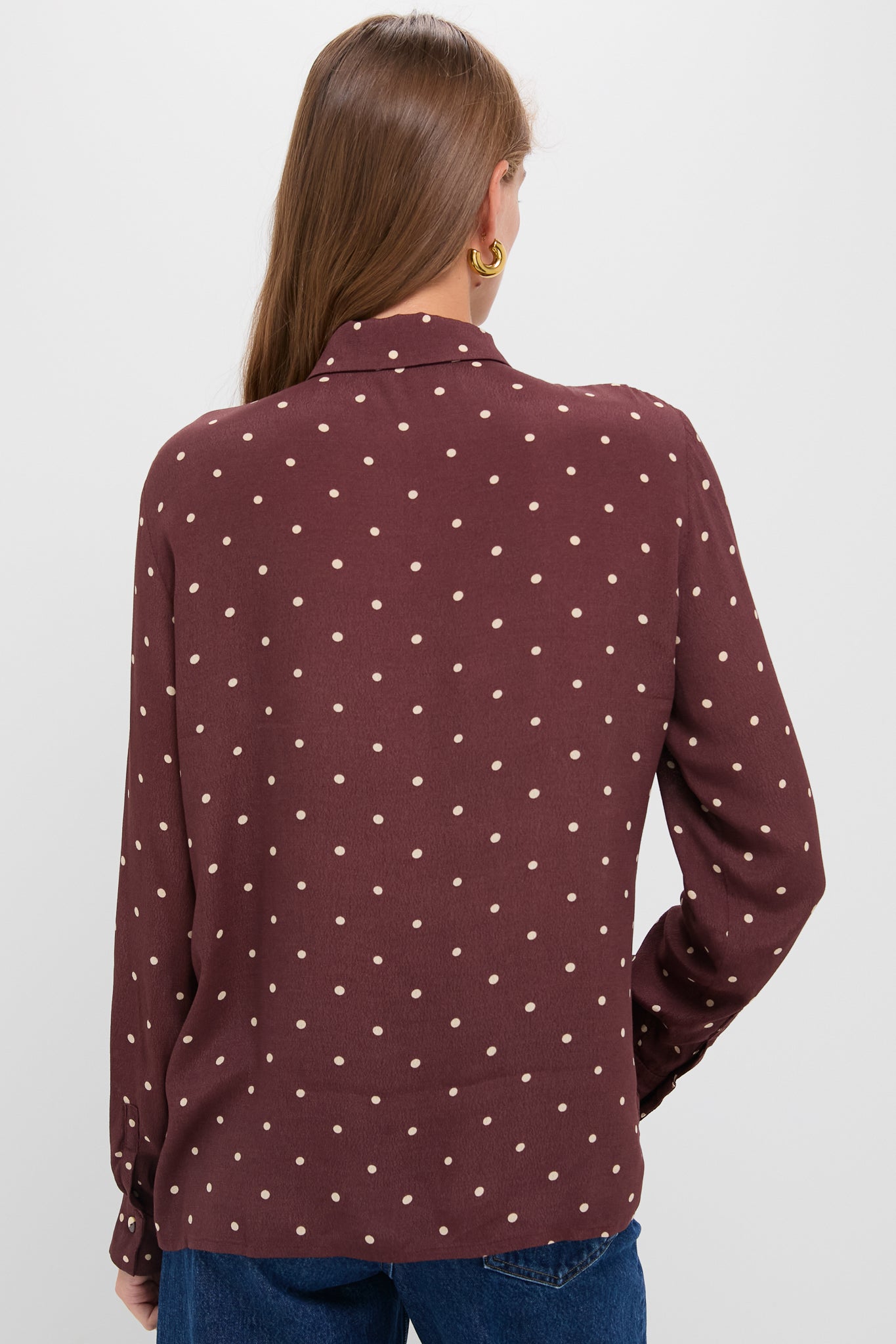 Back view of a person in the Night Print Crepe Shirt, a classic burgundy blouse with beige polka dots, paired with jeans, exuding effortless and high-end style.