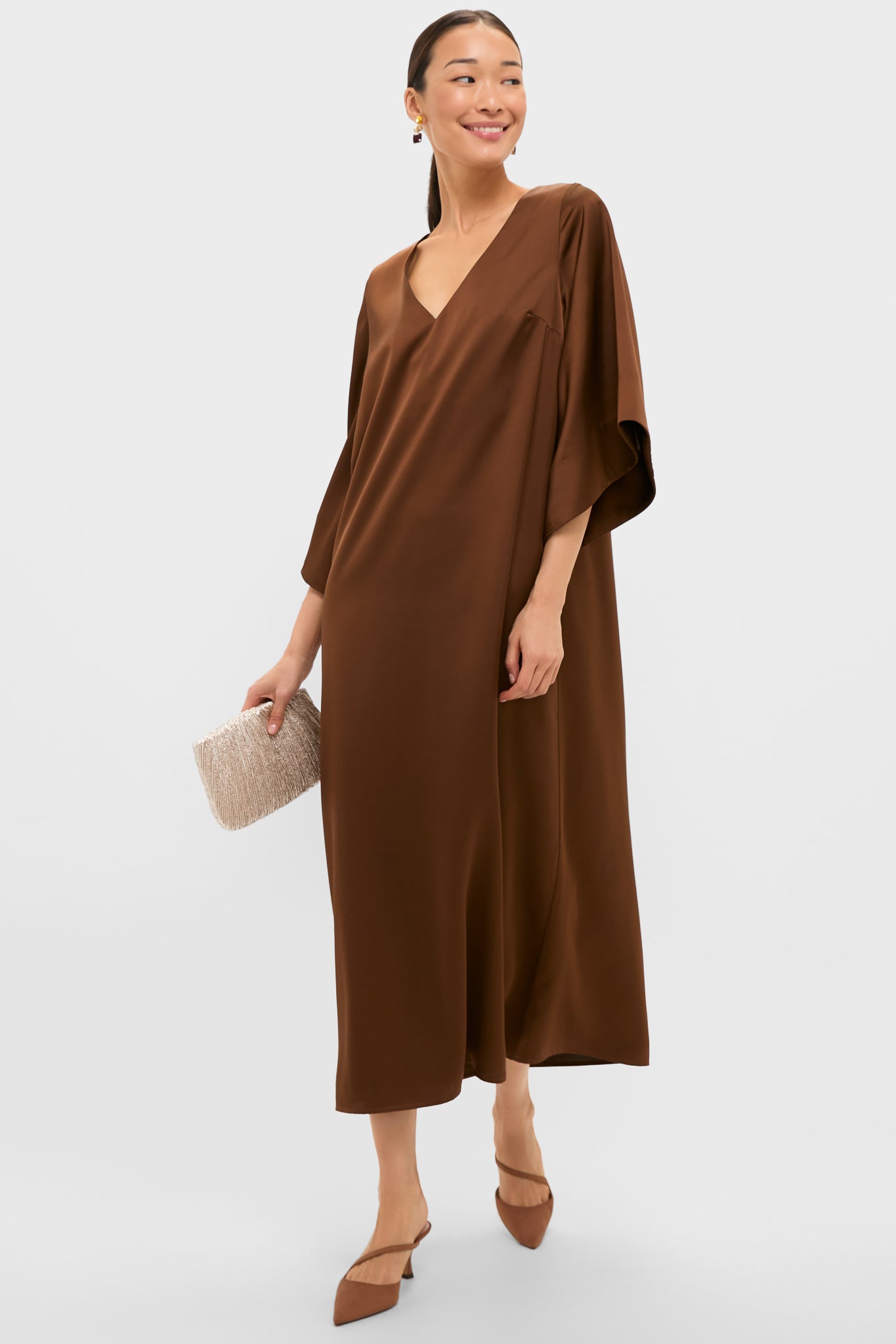 Woman in a chocolate-brown dress showcases the classic, effortless Chestnut Moire Mimi Heels, paired with a light-neutral clutch, embodying Tuckernuck's high-end, fun style.
