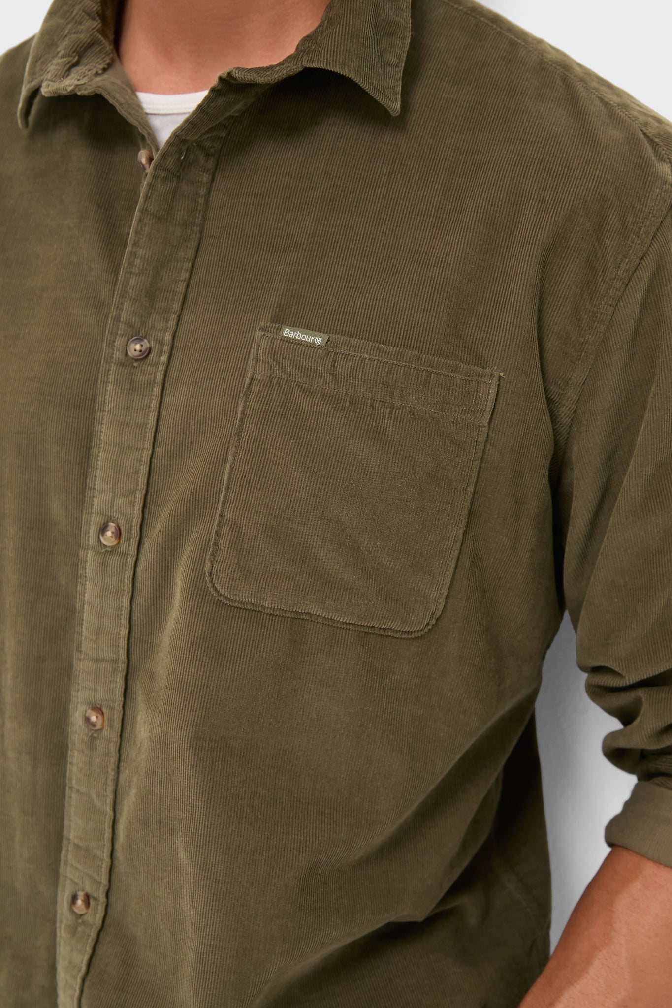 Close-up of a classic, olive Bramside Relaxed Cord Shirt with a chest pocket, button placket, and rolled sleeve, embodying effortless, high-end style.
