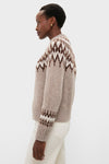 Model wearing the Taupe Fairisle Thatcher Crewneck, a classic, high-end alpaca blend sweater with an effortless Fair-Isle pattern, paired with light trousers.