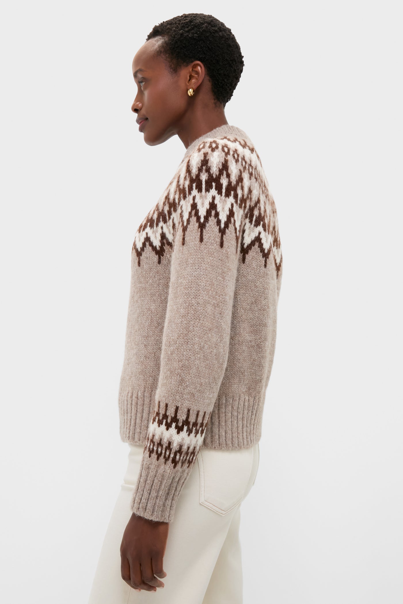 Model wearing the Taupe Fairisle Thatcher Crewneck, a classic, high-end alpaca blend sweater with an effortless Fair-Isle pattern, paired with light trousers.