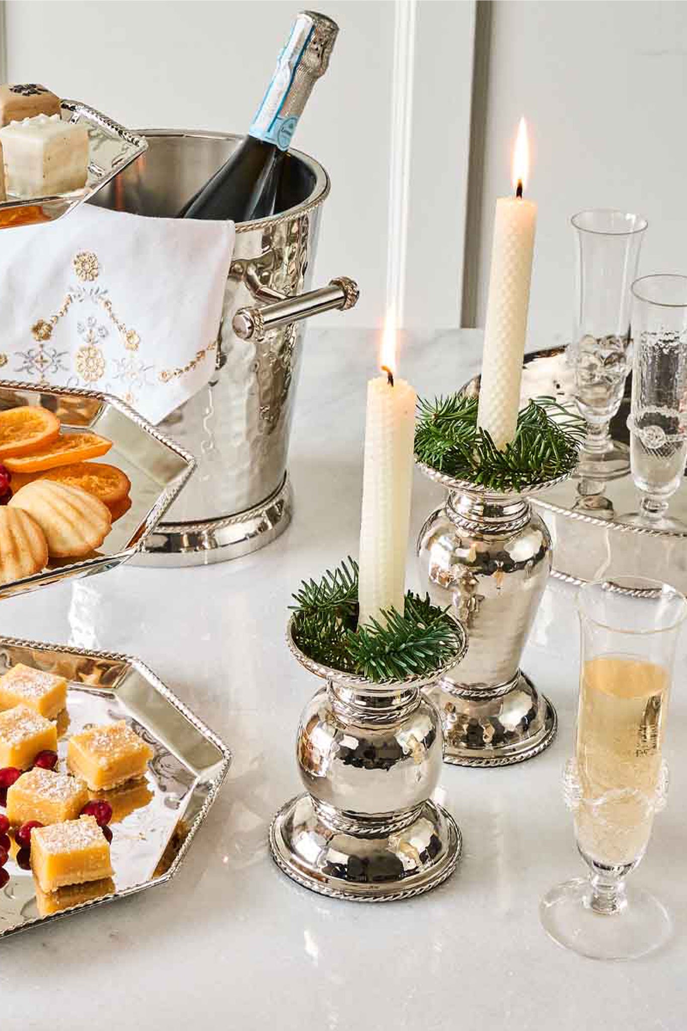 Graham 7 Pillar/Taper Candle Holder adds classic elegance to a festive tabletop with effortless charm, nestled among festive decor and sparkling wine for a high-end, fun gathering.