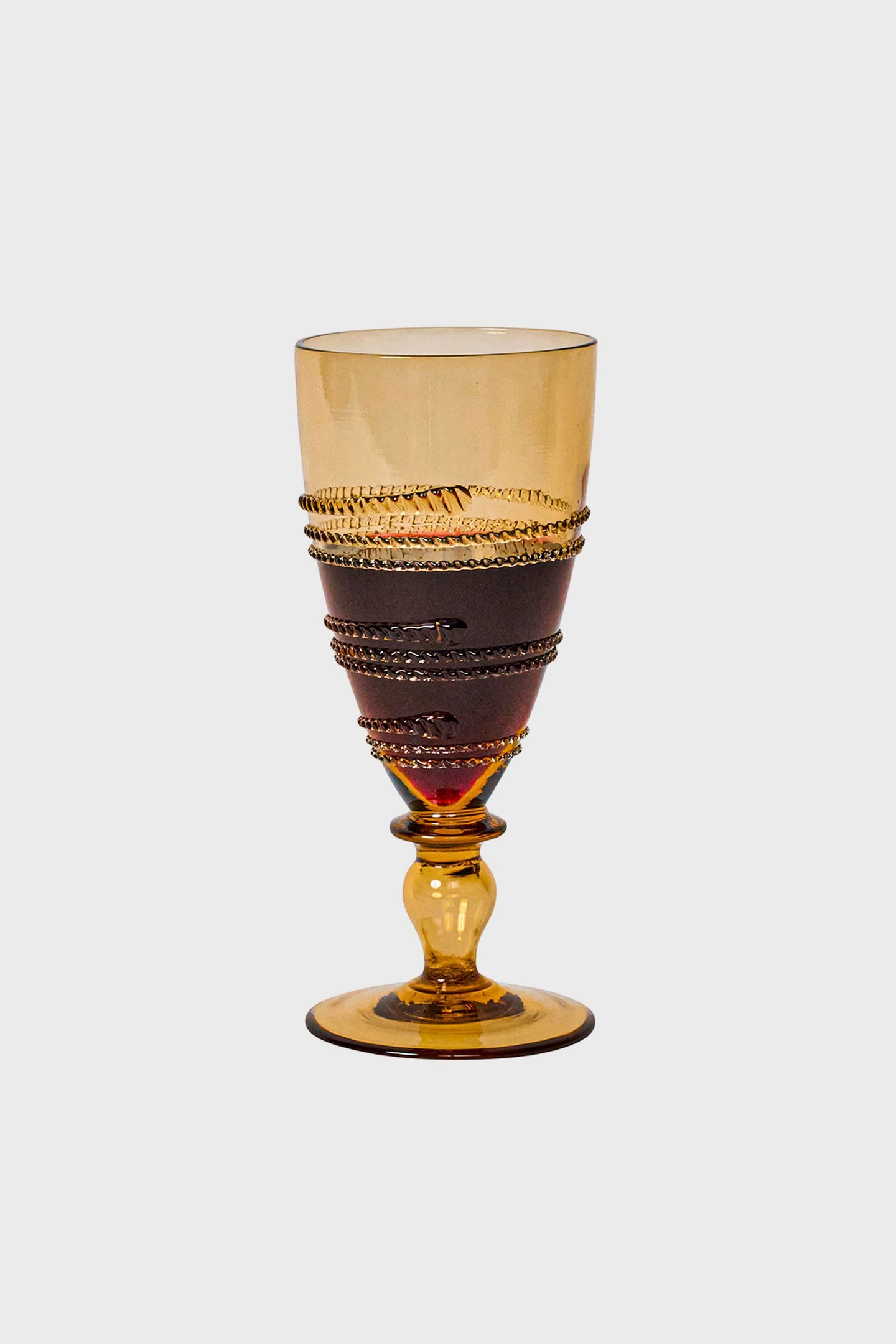 Amber Ella Goblet, a classic, high-end amber-tinted glass with effortless spiraling detail, mouth-blown for a fun, elegant touch to any occasion.