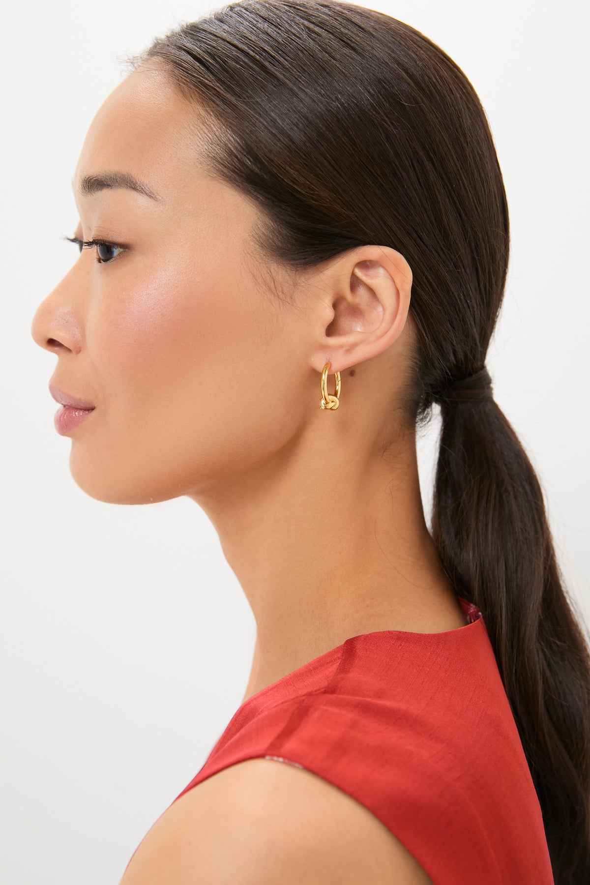 Woman wearing classic Gold Lucy Williams Pave Knot Small Hoop Earrings, showcasing their effortless and high-end design, perfect for adding a fun yet sophisticated touch to any look.