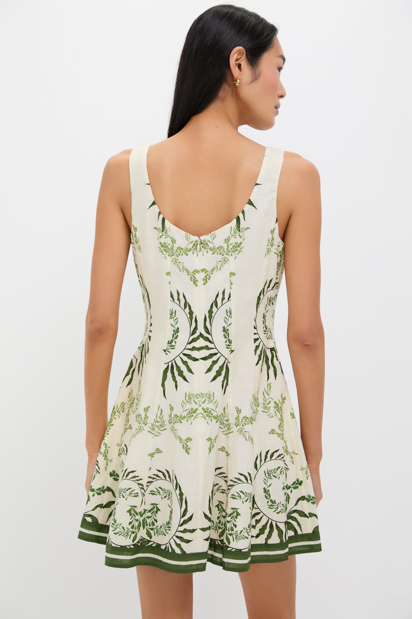 Back view of woman in the Ireland Green Layla Mini Dress, showcasing its classic, effortless style with a high-end botanical motif and fun, flared silhouette.