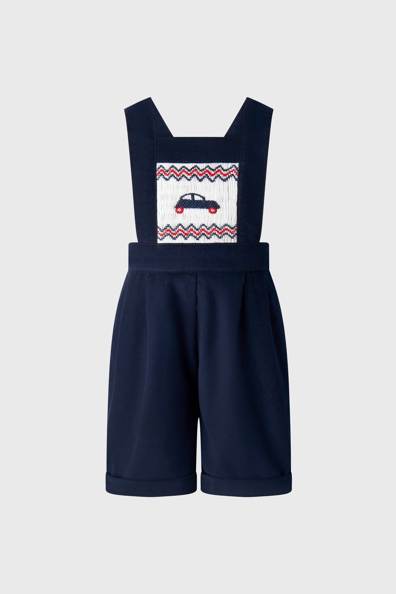 Classic Car Smocked Dungarees featuring an effortless, fun embroidered car design on a smocked panel, adjustable straps, and rolled cuffs, embodying high-end children's fashion.