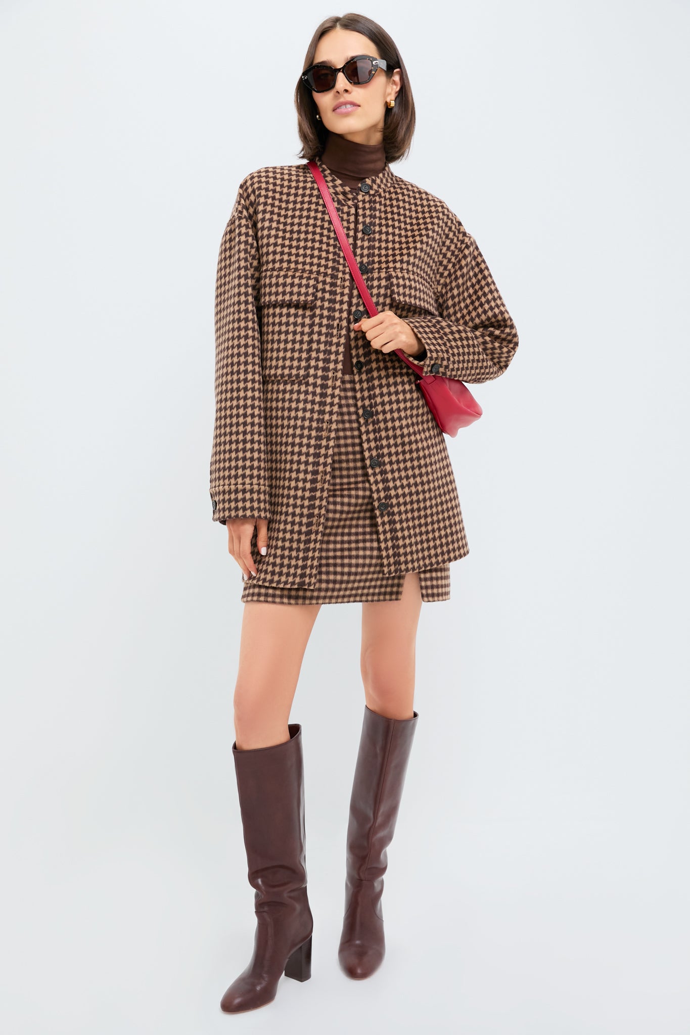 Woman in a classic Noir and Noisette Mimi Mini Skirt, styled with a turtleneck, shacket, and knee-high boots for an effortless, high-end look.