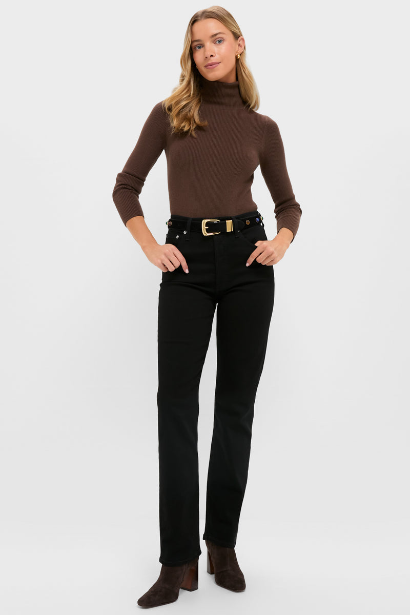 A woman faces forward in a brown turtleneck, AGOLDE high-rise straight-leg jeans with comfort stretch, a belt, and brown ankle boots, set against a plain white background.