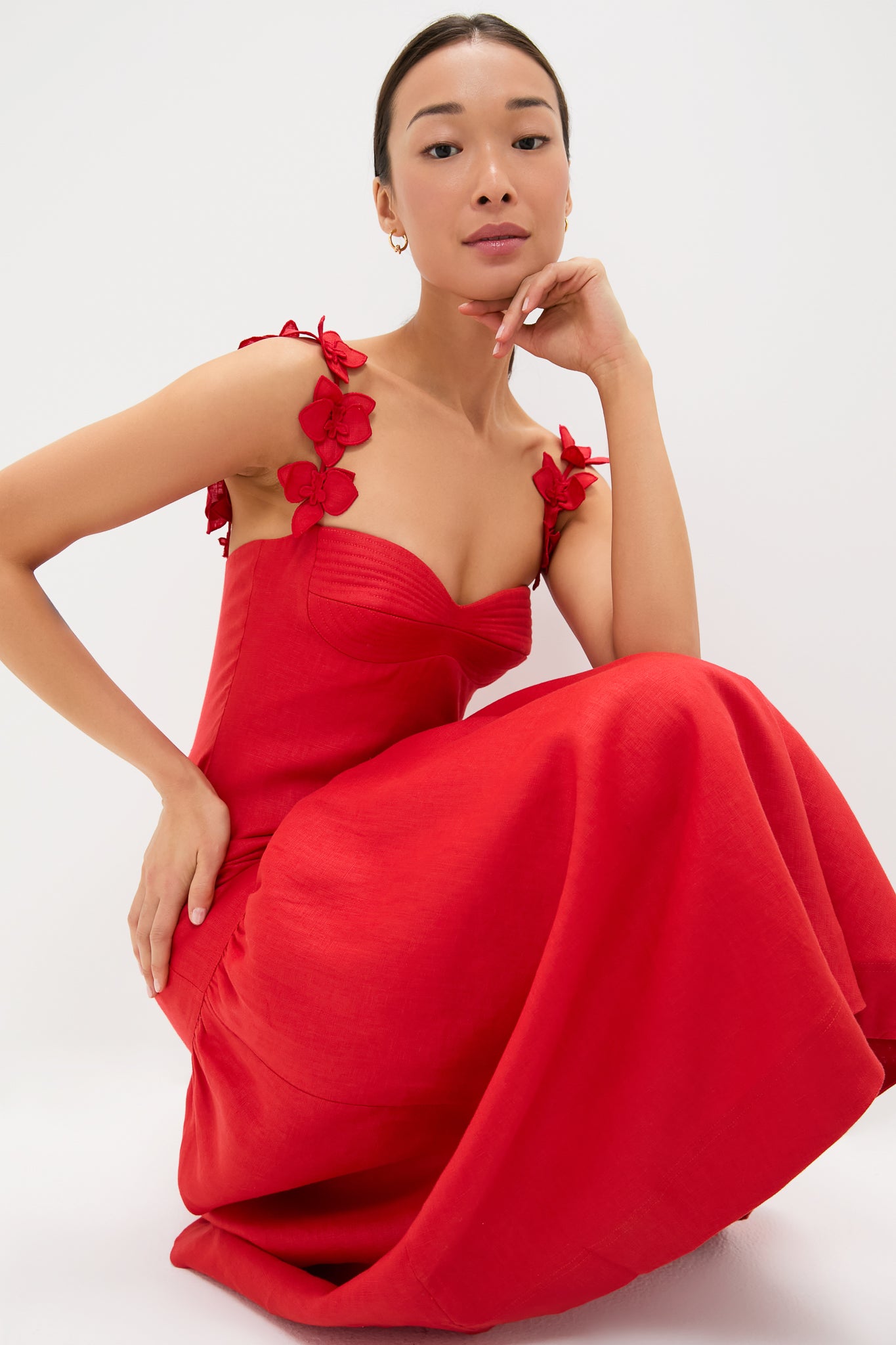 Woman wearing Red Ser Arte Embellished Maxi Dress with sculpted bodice and flower appliqués, exuding classic, effortless elegance, embodying high-end, fun style.