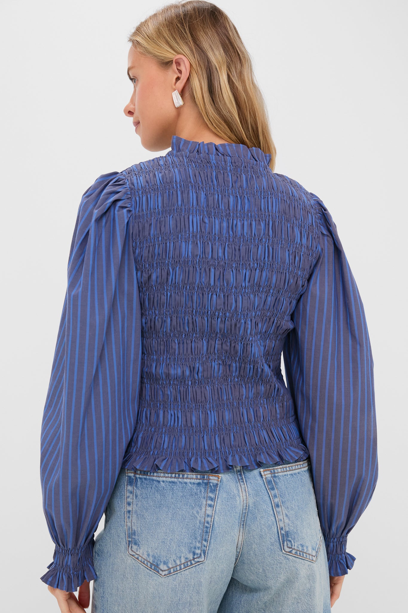 Morgan Blue Willow Top: back view of a classic, effortless, smocked blouse with ruffled cuffs and hem, styled with light-wash, high-waisted denim for a fun, high-end look.